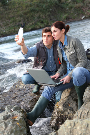 A Male and Female testing water of natural river 