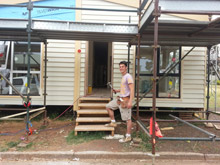 Joel Worth standing in front of an under construction transportable home