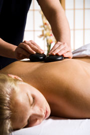 Therapist placing stiones on Client's back