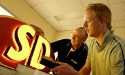Student and Teacher in front of red and yellow lightbox