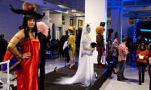 Models in character makeup on podium waiting to be judged