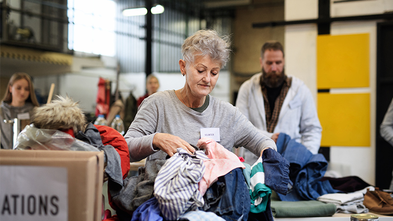 A volunteer sorts through clothing donations.