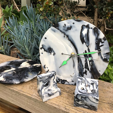 Clock and other objects made of black & white, swirling plastic