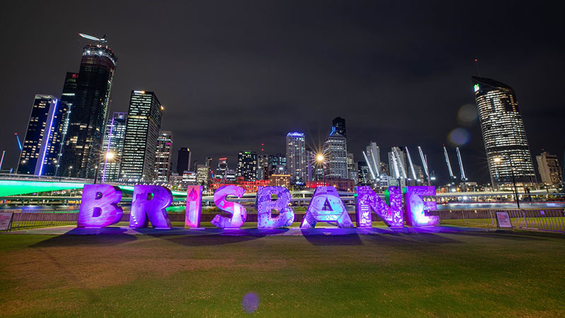 Illuminated 'Brisbane' sign at night.