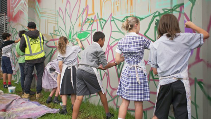 Group of school student in uniform paint a mural