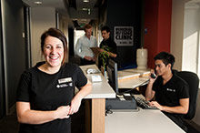Students working at the reception desk of the massage clinic
