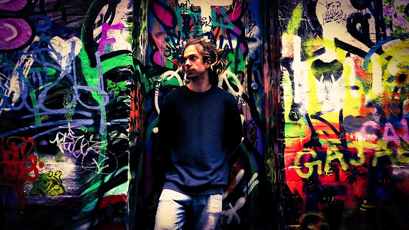Steven-lay-artist-standing-in-front-of-graffiti-mural 