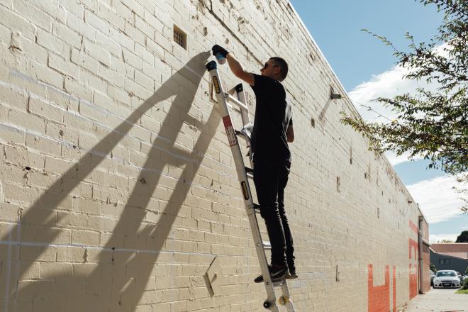 Tom Gerrard installing his shortlisted artwork for the Street Art category
