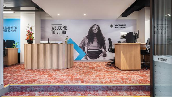 Our reception at ground floor provides a welcoming face and support to our students. A carpetted room with reception desks and seating areas. A large Victoria University banner is in the background, welcoming students to the campus.