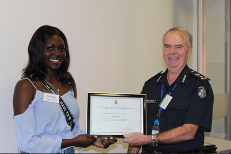 Alek, a participant of the Victoria Police Cultural Inclusion Recruitment Program, receiving her Certificate of Participation in the program from Superintendent Mark Porter. 