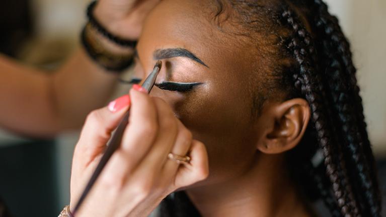  A makeup artist applying eye makeup to a client.