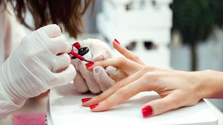  A beauty student giving a manicure in the salon. 