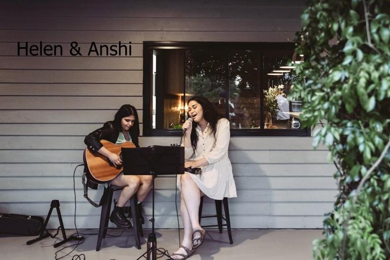  Helen & Anshi singing and playing guitar on a porch