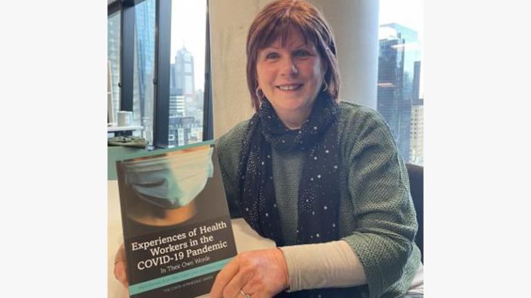  Professor Karen Willis holding a copy of 'Experiences of Health Workers in the COVID-19 Pandemic'.