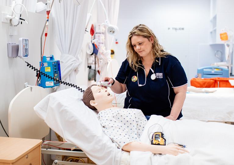 Nursing student Kristine Olsen with a dummy