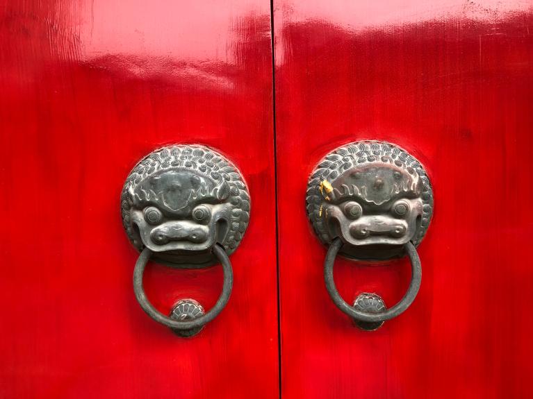 Closed red doors with brass knobs