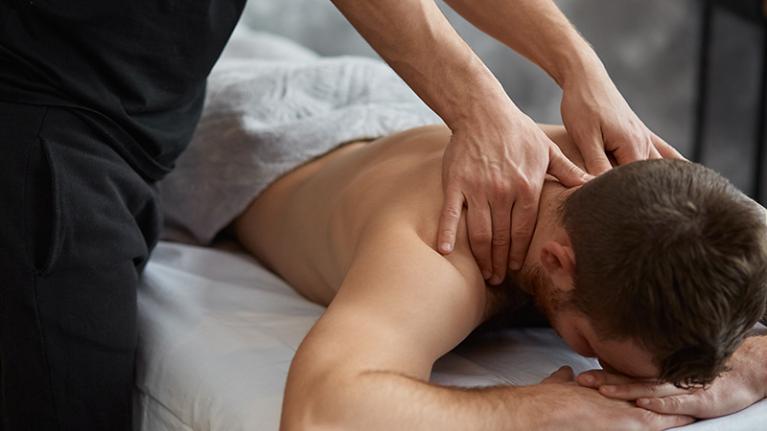 A remedial massage therapist giving a neck and shoulder massage in the clinic.