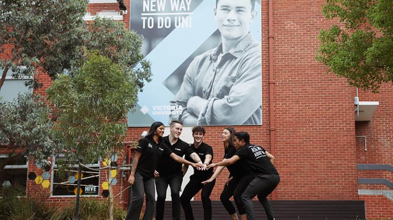 Student ambassadors in front of a VU billboard