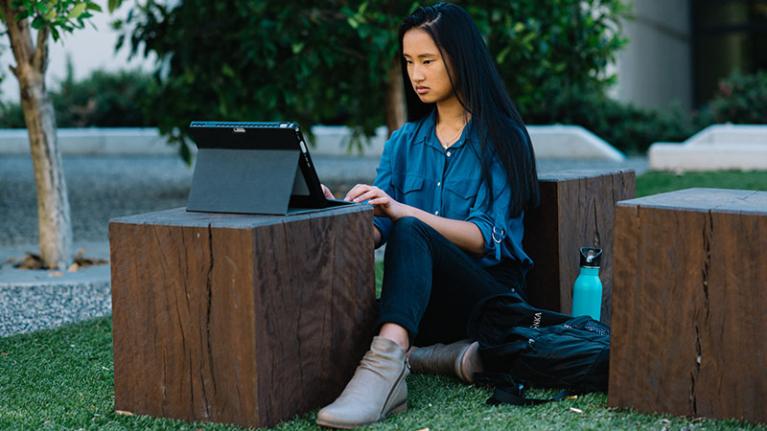 A student studies outside at Footscray Park Campus
