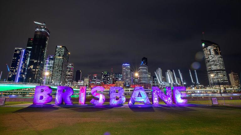  Bright sign spelling out 'Brisbane' in front of city skyscrapers.