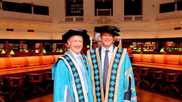 Chancellor Steve Bracks and Vice-Chancellor Adam Shoemaker in blue academic dress