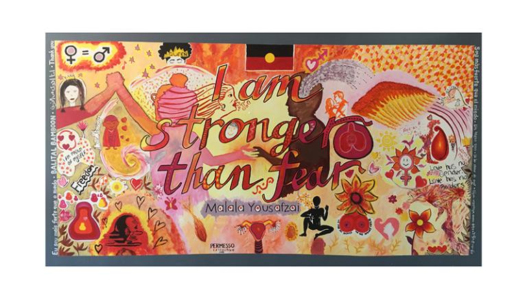 Mural with the words 'I am stronger than fear' and folk art depictions of women, flowers, etc in orange & yellows