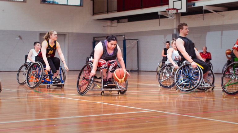 female athlete playing wheelchair basketball