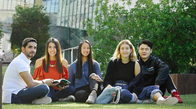  Group of international students sitting on the grass together at VU.