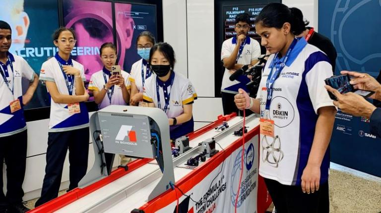 Secondary school students race miniature racecars they build themselves in F1 in Schools program