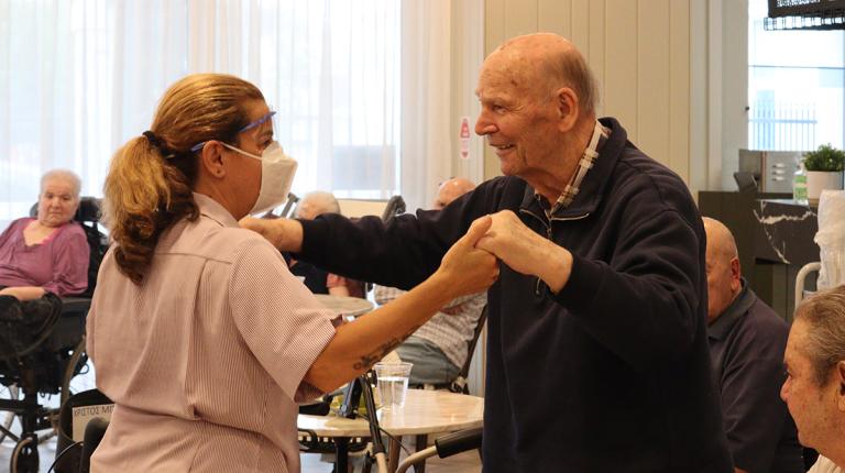 Photo credit: Fronditha Care An elderly man dances with a carer