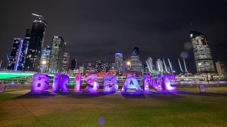 Illuminated 'Brisbane' sign at night.