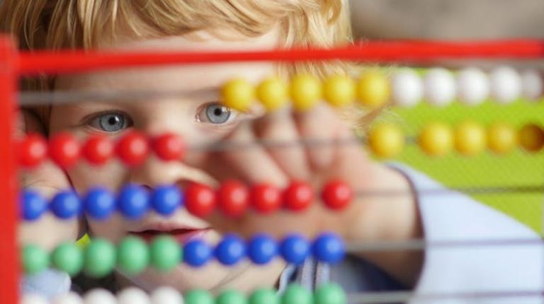 A child plays with an abacus.