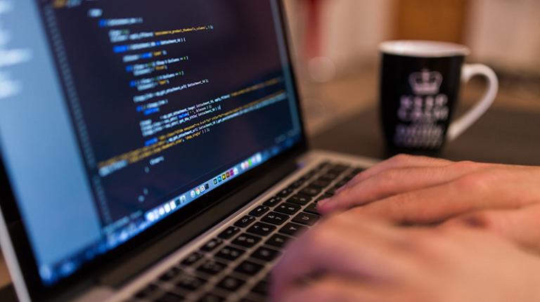 hands typing -- computer screen with code