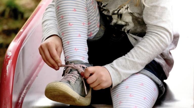 Young-girl-tying-shoe