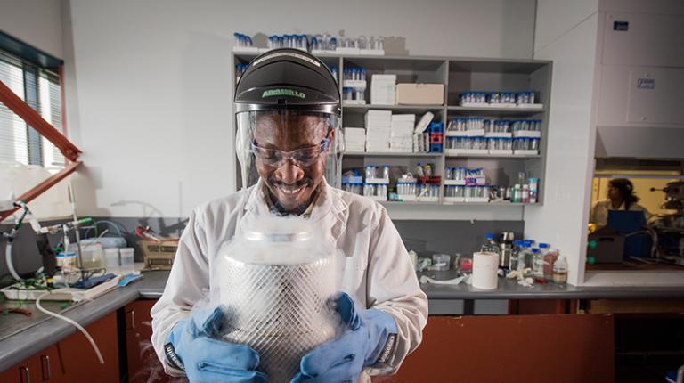 A person smiling while working in a research labratory.
