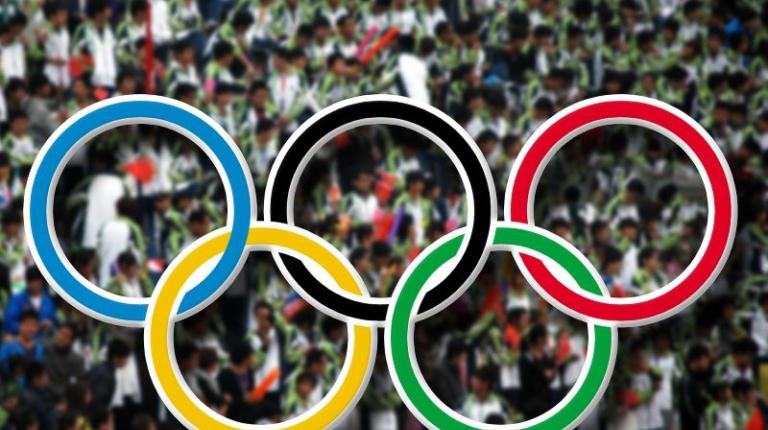 Olympic rings with crowd in back