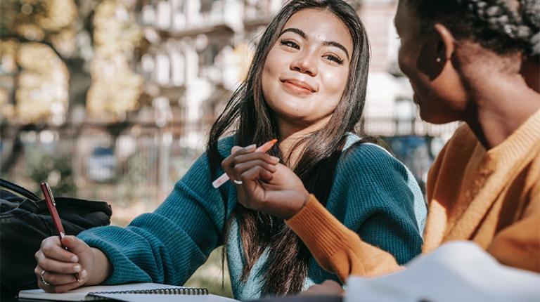 Two young women smiling, friendly