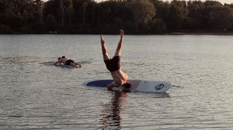Man falling off a surfboard in Australian lake