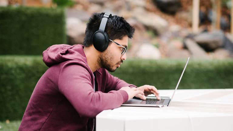 Student using a laptop outdoors on campus