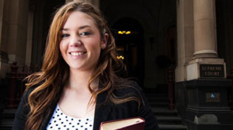 A Bachelor of Law student stands outside Victoria University. 