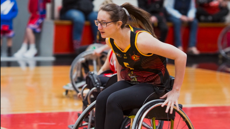 female athlete playing wheelchair basketball