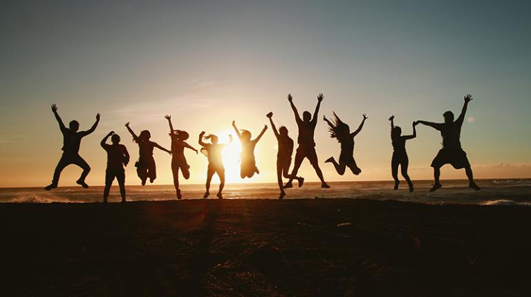 A group of people jumping in the air against a sunset, image by Belle Co