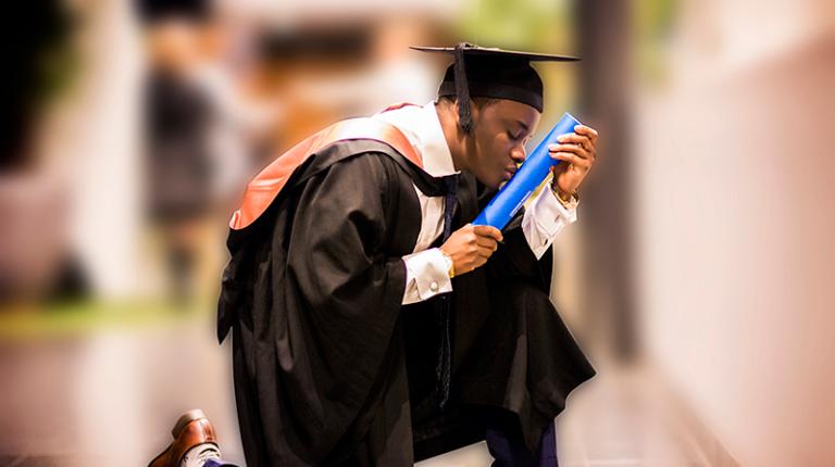 Student kneels to kiss degree