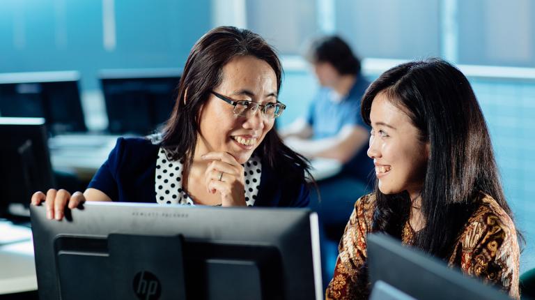  VU student and teacher working at computer.