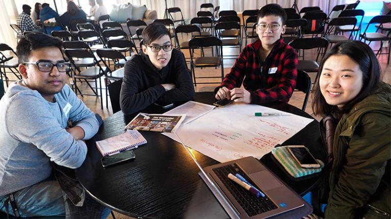Four university students of diverse background with paper project plans