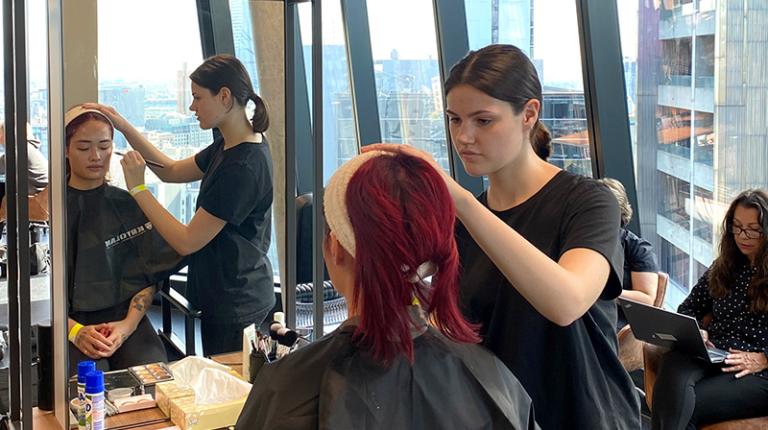 A beauty student doing makeup on a client in the VU City Tower salon.