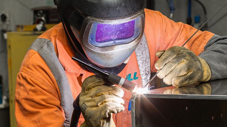  VU Polytechnic student wearing protective gear while welding.
