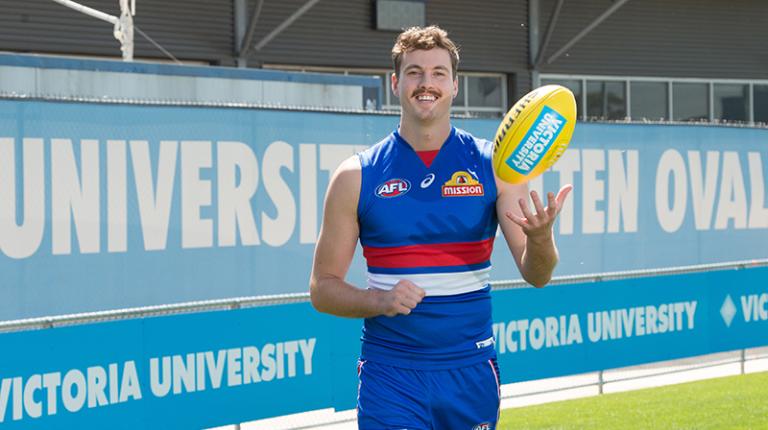 Zaine Cordy in Bulldogs uniform with a football