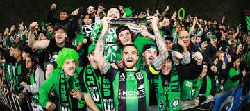  VU student Josh Risdon holds the A-League trophy and celebrates with fans after Western FC win the 2021/2022 Grand Final.