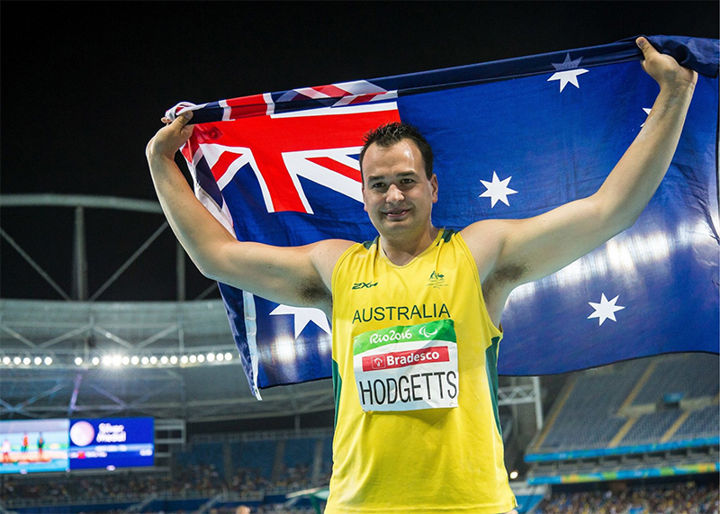 Todd Hodgetts holding the Australian flag at a competition.